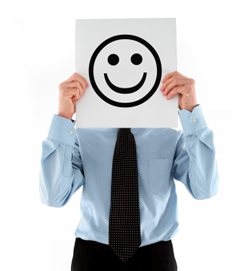 Man holding a smiley face in front of his face